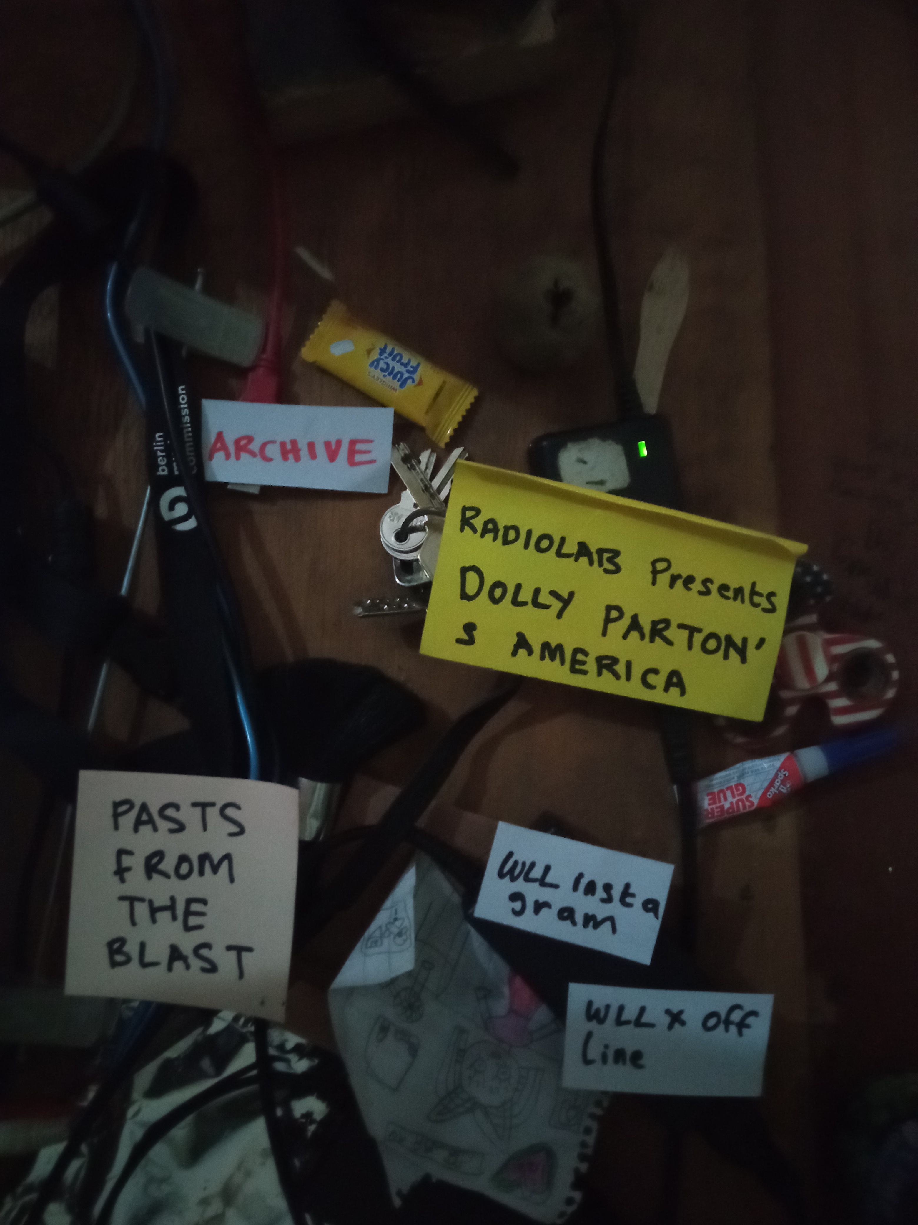 A desk covered with keys, cables and handmade paper labels